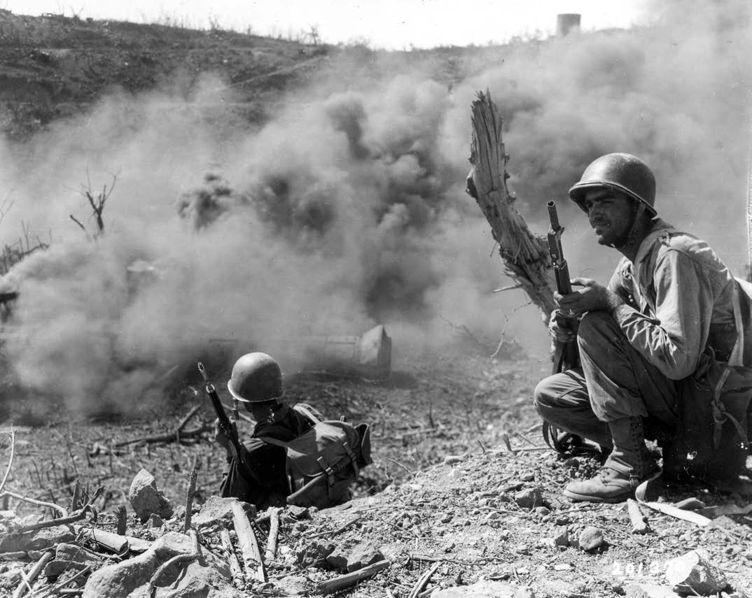 Private First Class Lyle O. Slaght, right, member of 503rd Parachute Infantry Regiment, scouts out area next to cloud of burning gasoline used to force Japanese soldiers out of hiding, on Corregidor Island, Philippine Islands, February 1945 (U.S. Army Signal Corps/Morris Weiner)